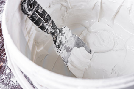 Spatula with putty on bathroom background.の写真素材