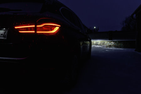Night driving in winter. Close-up of rear light of car in winter in dark.