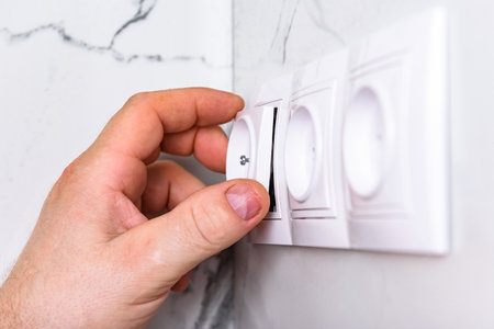 Installing outlet on white tile wall.
