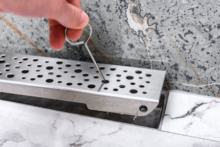 Hand open linear shower drain system using hook.