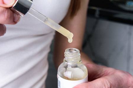 Young woman applying moisturizing facial serum.