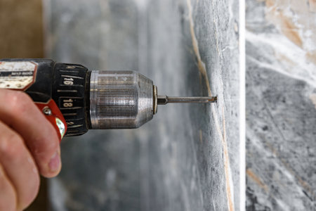 Drilling hole in tile with screwdriver.