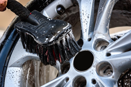 Man washing car's alloy wheels with brush.の写真素材