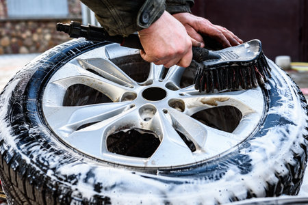Man washing car's alloy wheels with brush.の写真素材