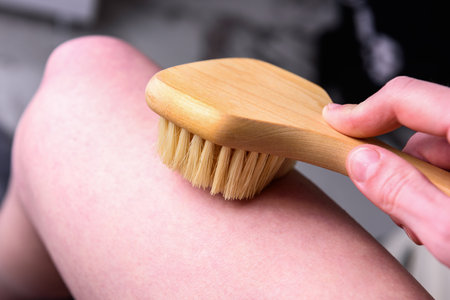 Woman's hand does a dry massage with a brush to prevent cellulite.の写真素材