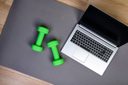 Fitness background with laptop and dumbbells. Home workout online concept.の写真素材