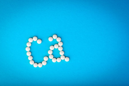 White pills forming shape to Ca alphabet on blue background.の写真素材