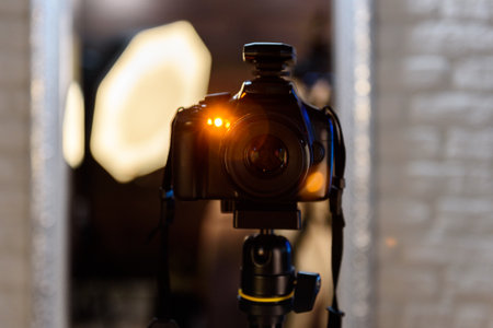 Professional digital camera on a tripod taking photo connected by a synchronizer to the flashlights...