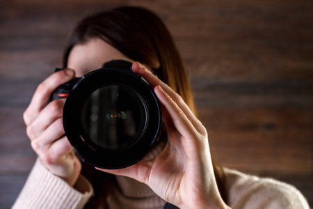 Professional photographer woman holding digital camera and taking photo.の写真素材