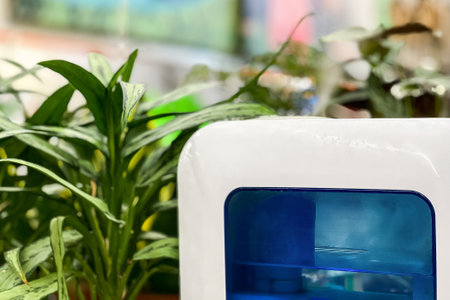 Modern air humidifier for indoor plants. Steam vaporizer standing near greenhouse plants.の写真素材