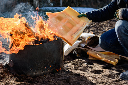 A man burning old unwanted things from home in a bonfire in early spring.の写真素材