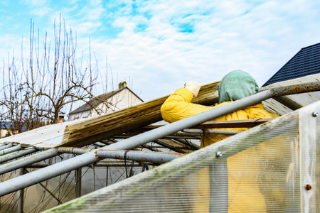 Greenhouse repair. Removal old polycarbonate using knife.の写真素材