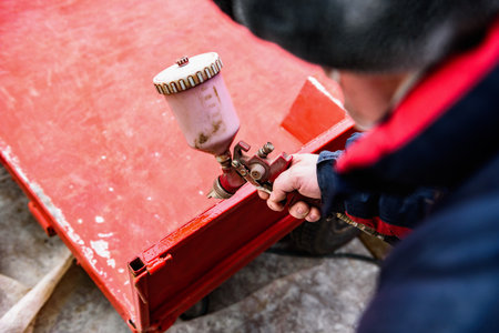 Rebuilding upgrading and modifying trailer. Man painting a metal trailer with spray gun.の写真素材