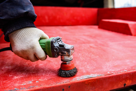 Rebuilding upgrading and modifying trailer. Man grinding old paint from trailer.の写真素材
