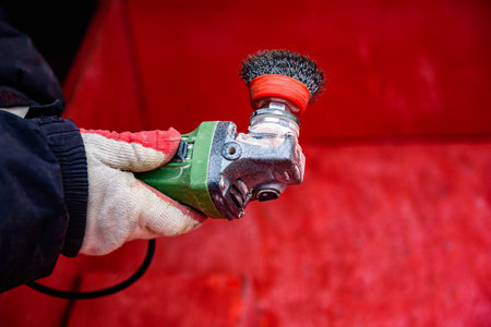 Rebuilding upgrading and modifying trailer. Man grinding old paint from trailer.の写真素材
