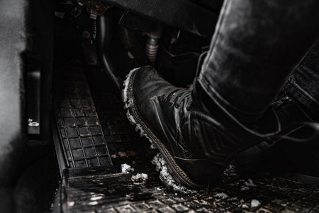 Woman's legs in winter boots with snow driving a car.の写真素材