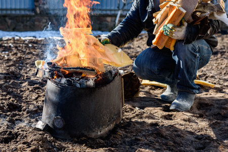 A man burning old unwanted things from home in a bonfire in early spring.の写真素材