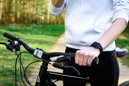 Close-up of woman cyclist hand on handlebars of mountain bike outdoors.