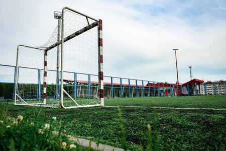 Outdoors football court with artificial turf. Football goal grass of a city stadium.の写真素材