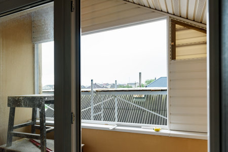 Installation of siding on the walls around the balcony window.