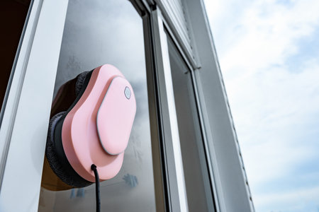 A robot window cleaner washes a window outdoor in summer dayの写真素材
