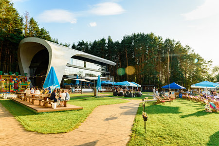 People at a sunny terrace with umbrellas at a restaurantの写真素材