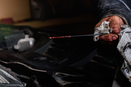 Car mechanic checking the motor oil level on the dipstickの写真素材