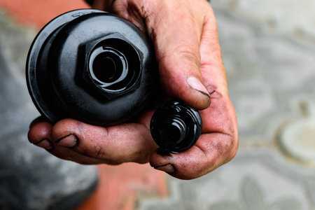 A car mechanic cleaning the body part of an old oil filter using a special cleanerの写真素材