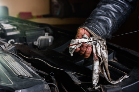 Car mechanic checking the motor oil level on the dipstickの写真素材