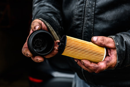 A car mechanic holding a new oil filter in his handsの写真素材