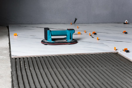 Laying the tiles using electric suction cup with automatic pumpingの写真素材