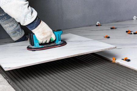 Laying the tiles using electric suction cup with automatic pumpingの写真素材