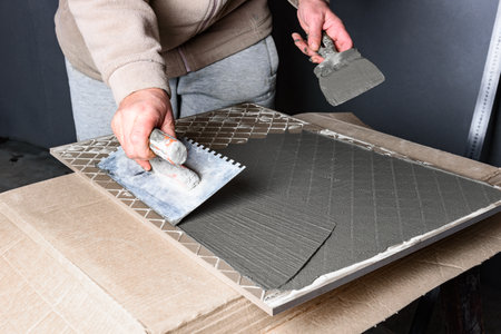 Applying glue on ceramic tile with a spatula