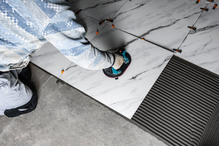 Laying the tiles using electric suction cup with automatic pumpingの写真素材