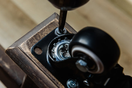 Screwing furniture wheels with brakes to a table with a screwdriver