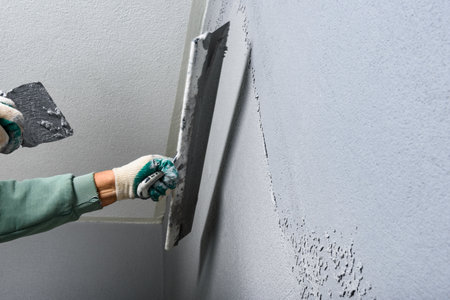 Applying concrete pebble plaster using putty knife.の写真素材