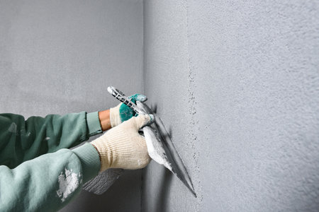 Applying concrete pebble plaster using putty knife.の写真素材