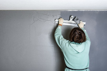 Applying concrete pebble plaster using putty knife.の写真素材