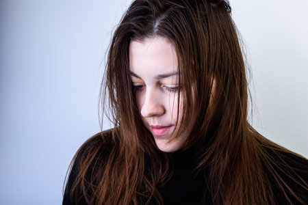Young woman with dirty greasy hair on gray background