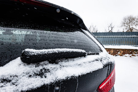Frozen windshield wipers and window on the car in winter