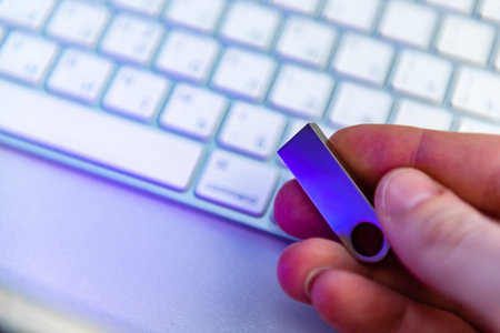 Silver USB flash drive on white keyboardの写真素材