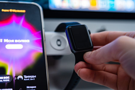 Hand putting on charging smart watch for wireless charging