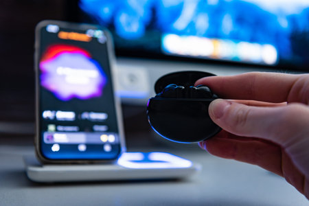 Hand putting on charging wireless headphones for wireless charging