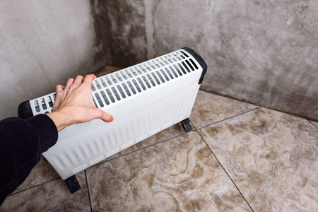 Modern portable electric heater, heating the basement. Drying the walls of a damp room