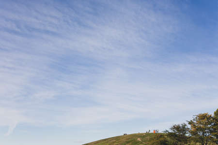 Blue sky and a hill where people rest. Fall.の写真素材