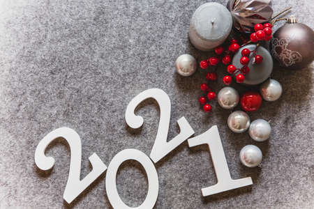 New Year decorations, red and white balls, numbers 2021 on a gray background. Place for text.