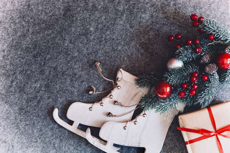 New Year decorations, wooden skates, red and white balls, christmas tree on a gray background. Place...
