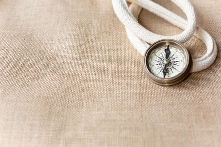 The compass in vintage style is on a burlap background. Free space for text. View from the top point.の写真素材
