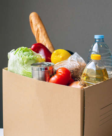 A set of products is in a cardboard box on the table. The topic is essential products.の写真素材