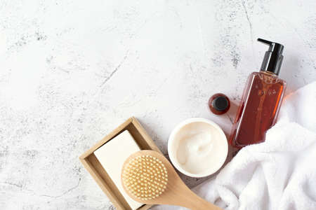 spa and beauty. A set of cosmetics, a wooden brush and a white terry towel are on a gray background. Free space for text. view from the top point.の写真素材
